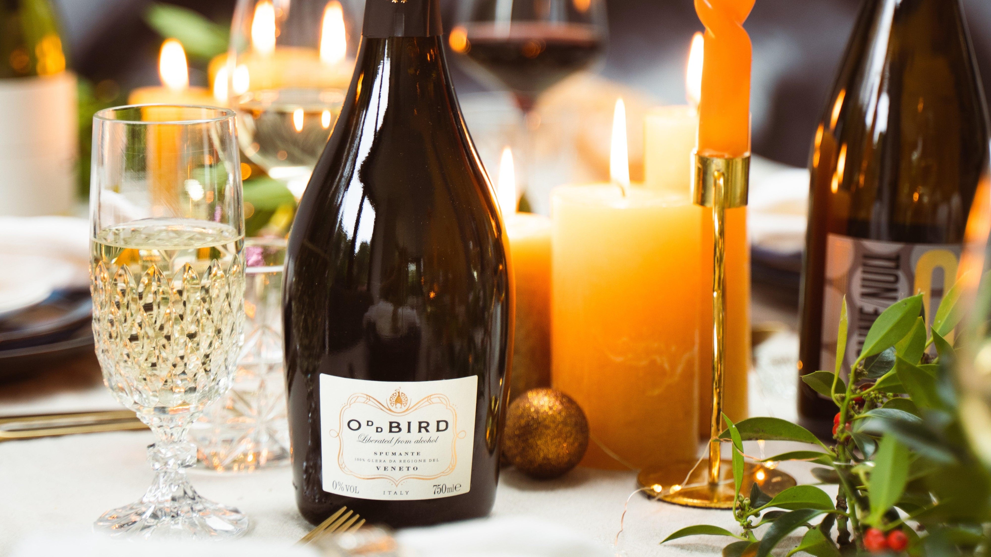 Fles alcoholvrije prosecco van Oddbird op een feestelijk gedekte tafel.