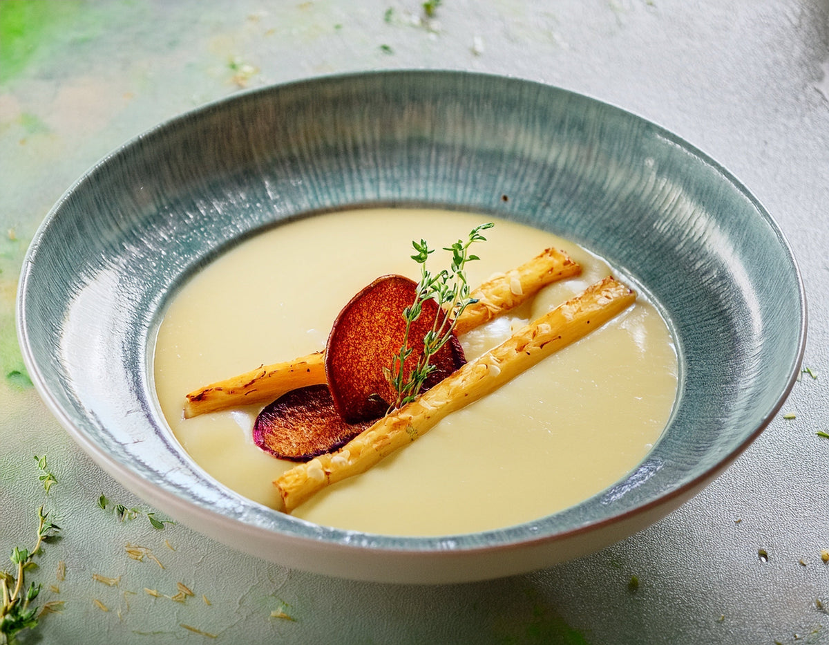Romige aspergesoep met witte asperges en groenten in een stijlvolle kom | World of NIX