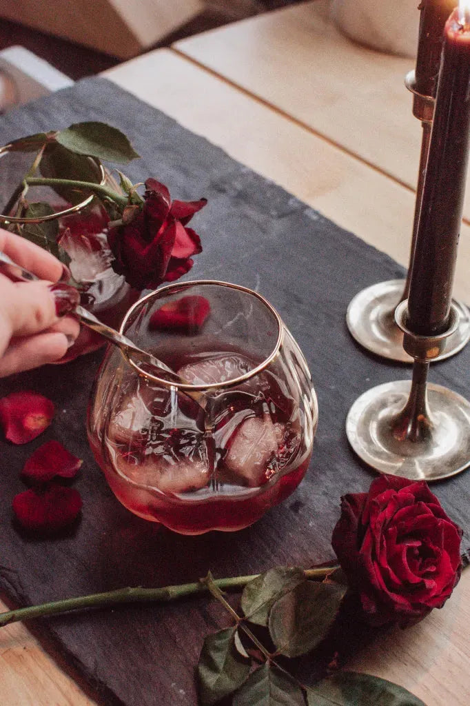 Stijlvol alcoholvrij drankje met ijsblokjes, rode rozen en kaars op tafel | World of NIX