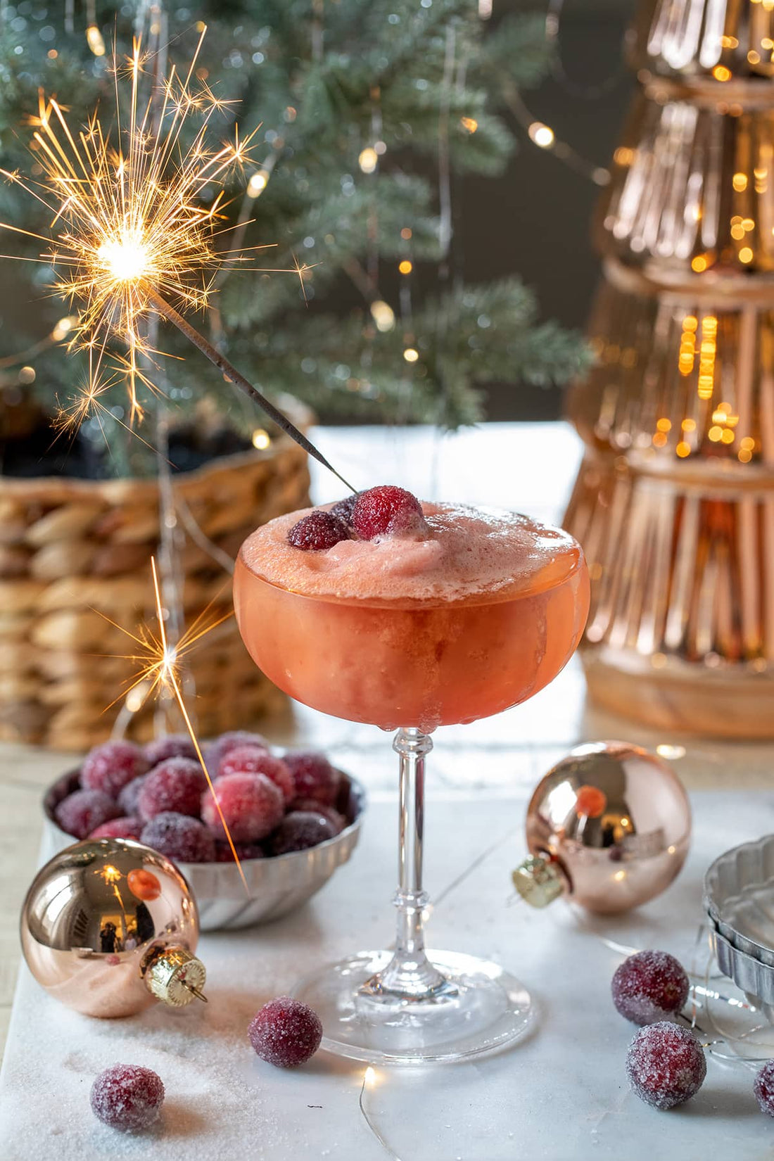 Feestelijk alcoholvrij champagne dessert met rode bessen, vuurwerksterretje en kerstdecoratie | World of NIX