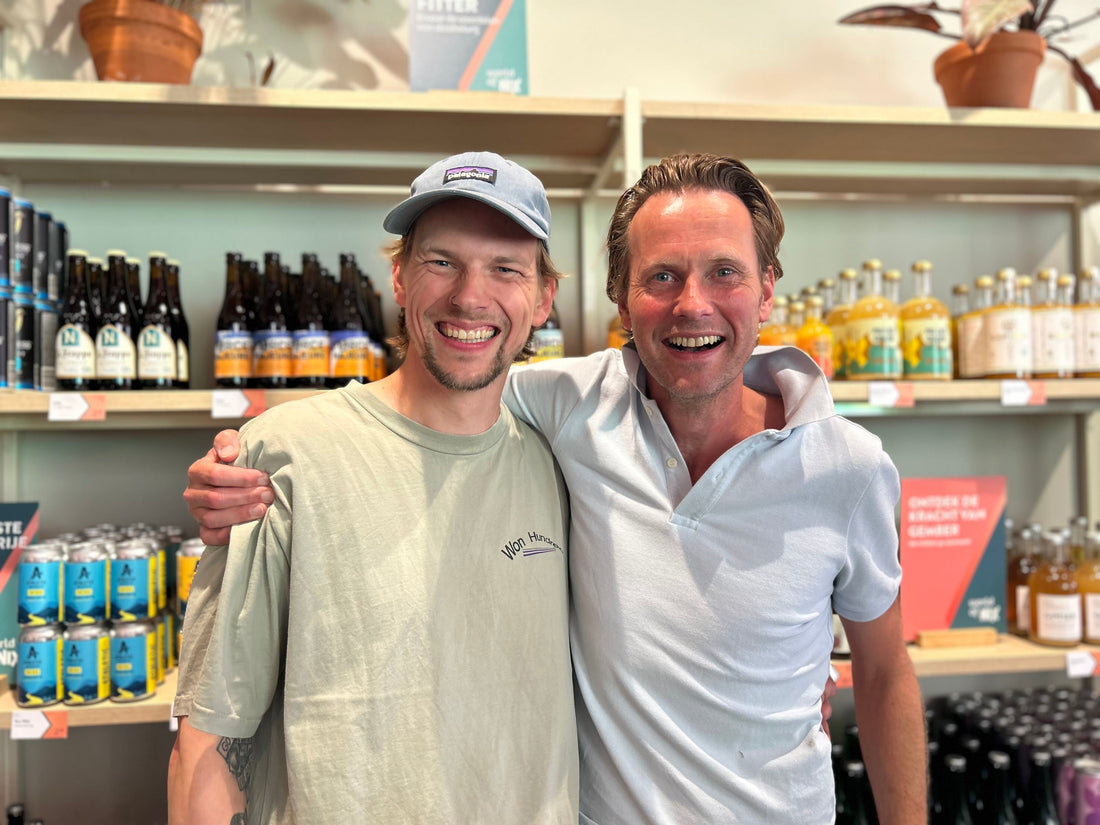 Twee lachende mannen in winkel voor schappen met alcoholvrije dranken | World of NIX