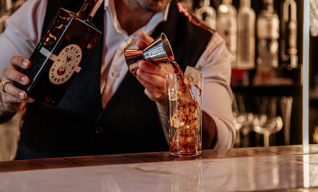 Barman schenkt alcoholvrije spirit in glas met ijs bij bar | World of NIX