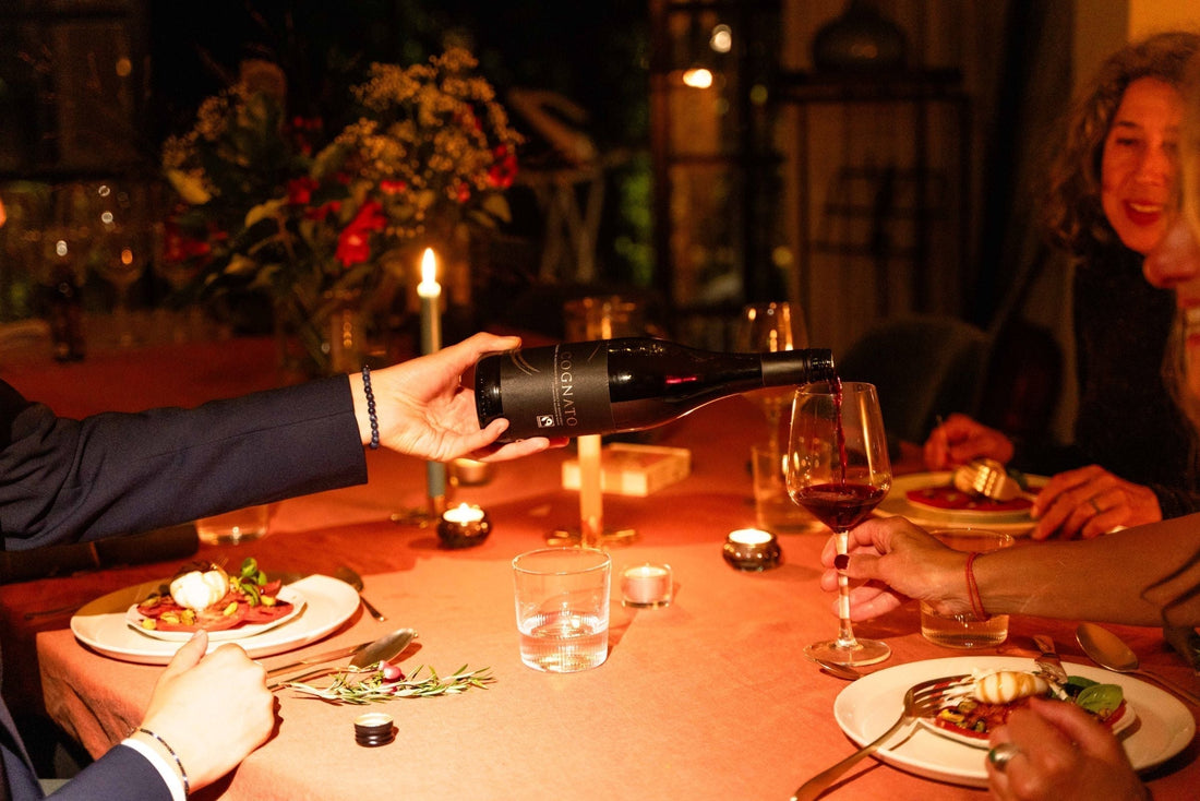 Alcoholvrije rode wijn wordt ingeschonken tijdens sfeervol diner, kaarslicht, elegante setting | World of NIX