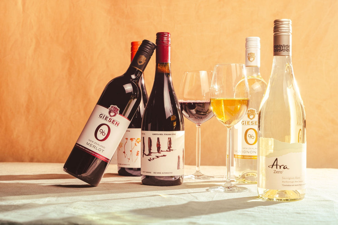 Assortiment alcoholvrije wijnflessen en glazen op tafel met lichte achtergrond | World of NIX