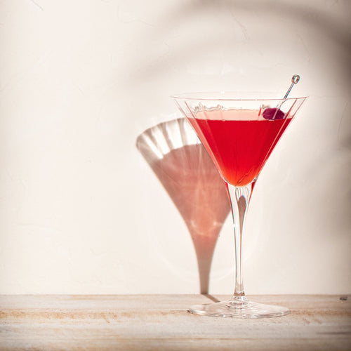 Stijlvolle alcoholvrije martini mocktail in een martiniglas met kers op lichte achtergrond | World of NIX