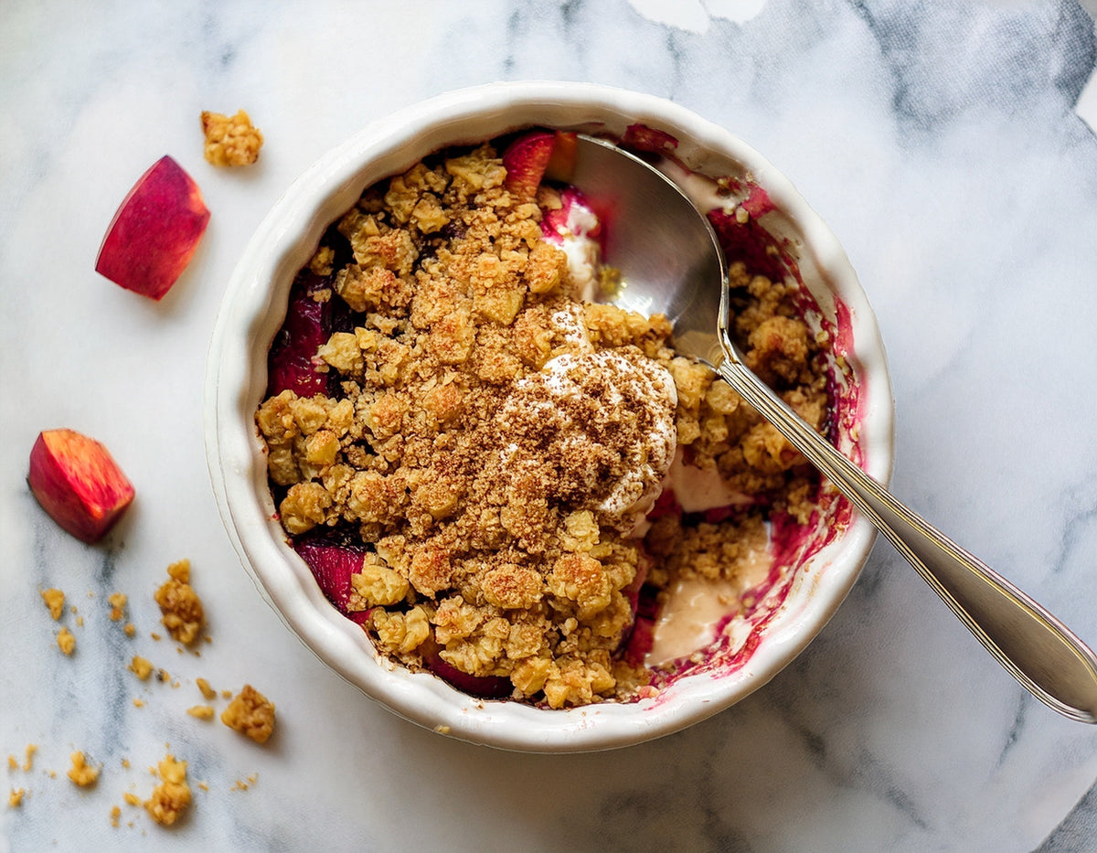Rabarbercrumble met bolletje ijs in ovenschaal op marmeren ondergrond | World of NIX