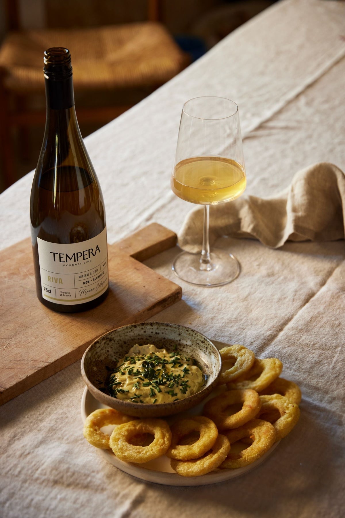 Fles Tempera alcoholvrije wijn met glas, borrelhapjes en dipsaus op tafel | World of NIX