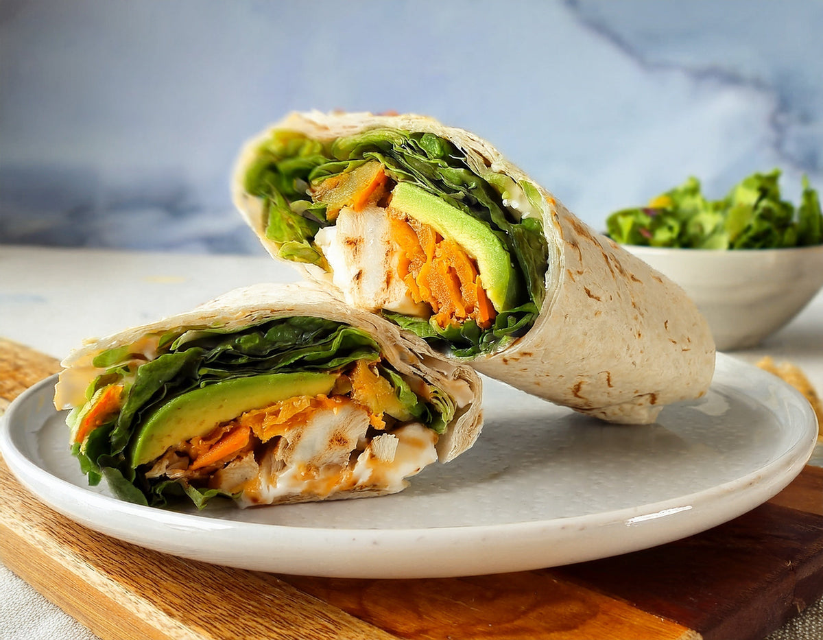 Wrap met halloumi, avocado en spinazie op een wit bord, gezonde lunch | World of NIX