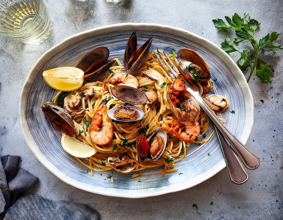 Zeevruchten pasta met garnalen, mosselen en citroen op een bord, mediterrane sfeer | World of NIX