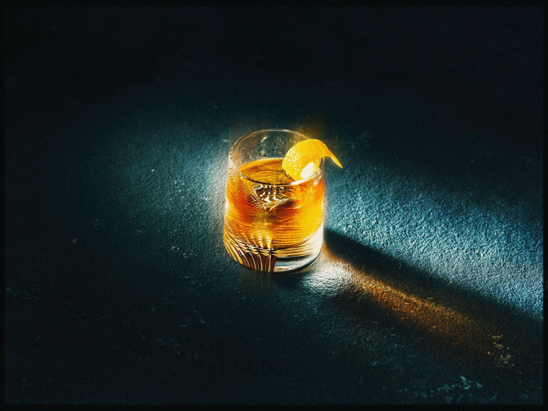 Glas alcoholvrije old fashioned cocktail met sinaasappelschil op donkere ondergrond | World of NIX