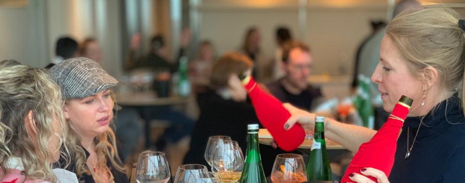 Vrouwen proeven alcoholvrije spirits en sparkling tea aan tafel in restaurant | World of NIX