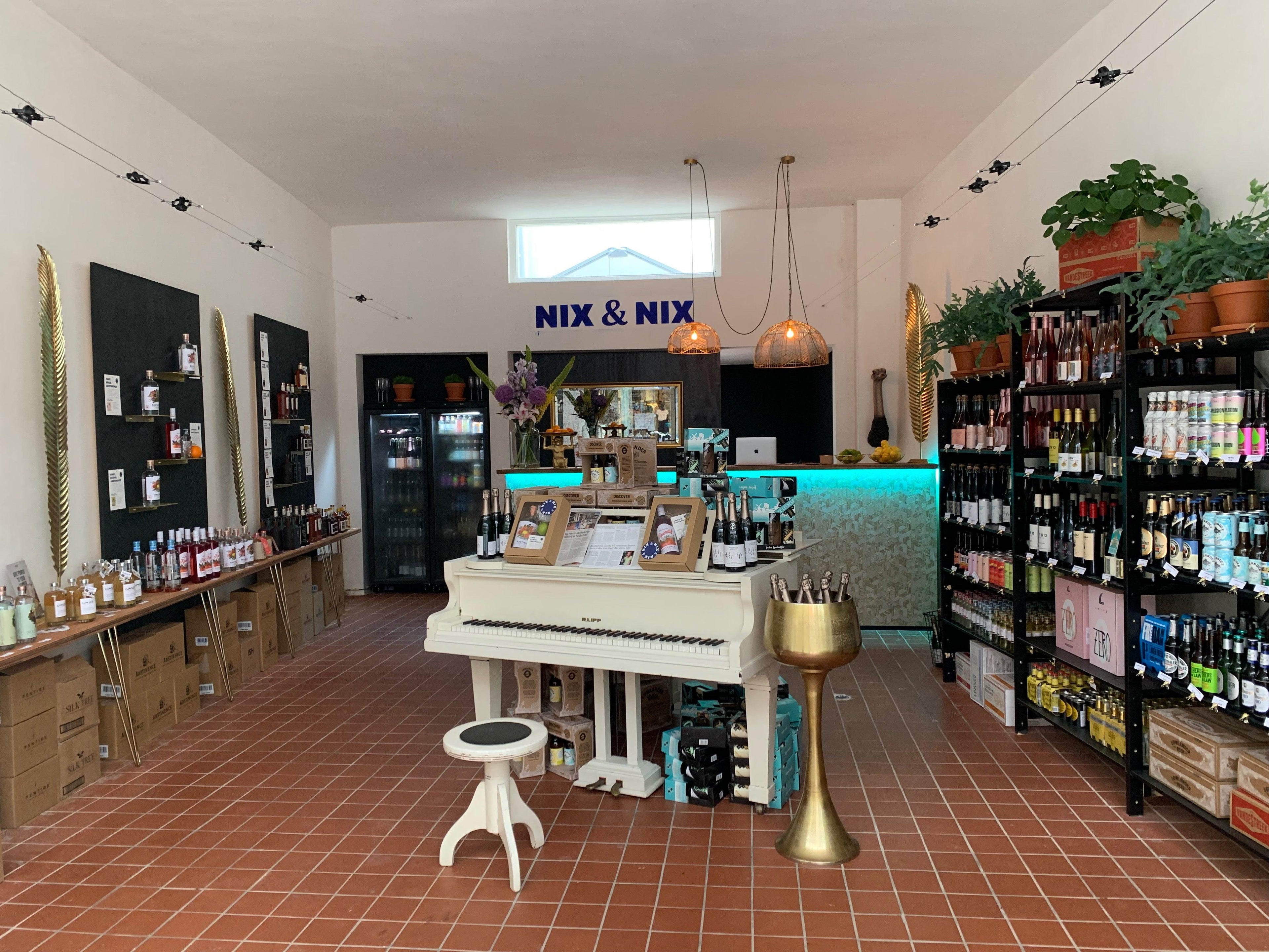 Interieur van alcoholvrije slijterij met witte piano, flessen 0.0 bier en wijnen | World of NIX