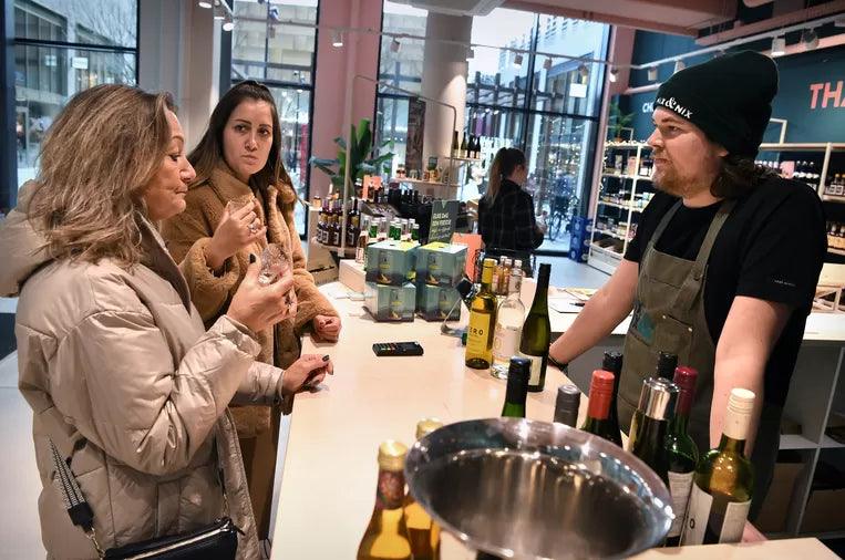 Twee vrouwen proeven alcoholvrije wijnen aan een bar in een World of NIX winkel | World of NIX