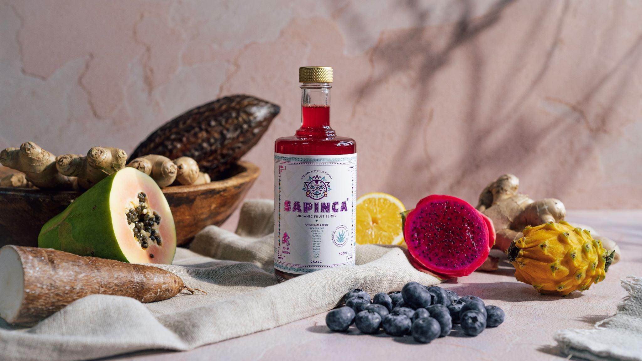 Sapinca alcoholvrij elixer fles met exotisch fruit, gember en bessen op tafel | World of NIX