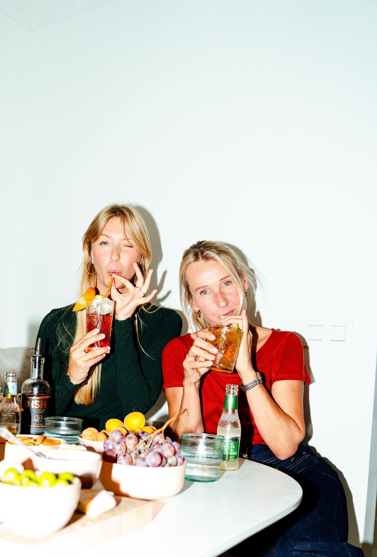 Twee vrouwen genieten van alcoholvrije cocktails en hapjes, tafel met fruit en drank | World of NIX