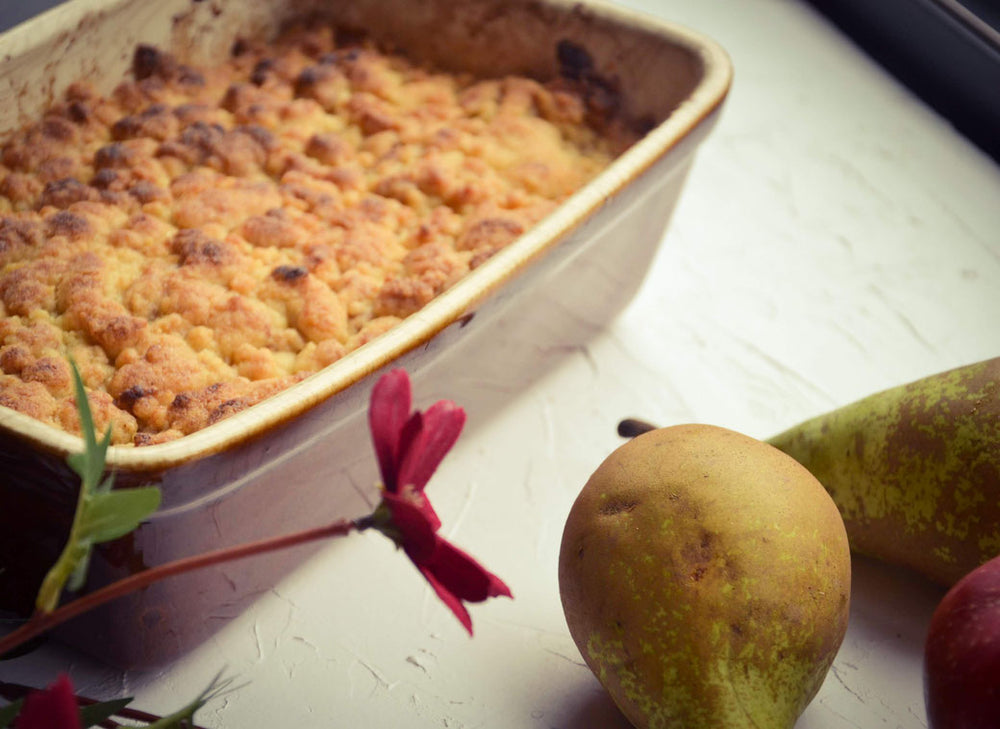 Herbstfrucht-Crumble mit Haferflocken und Zimt, serviert mit Schlagsahne