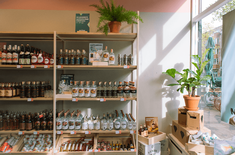 Winkelrek met alcoholvrije spirits, frisdrank en planten bij daglicht | World of NIX