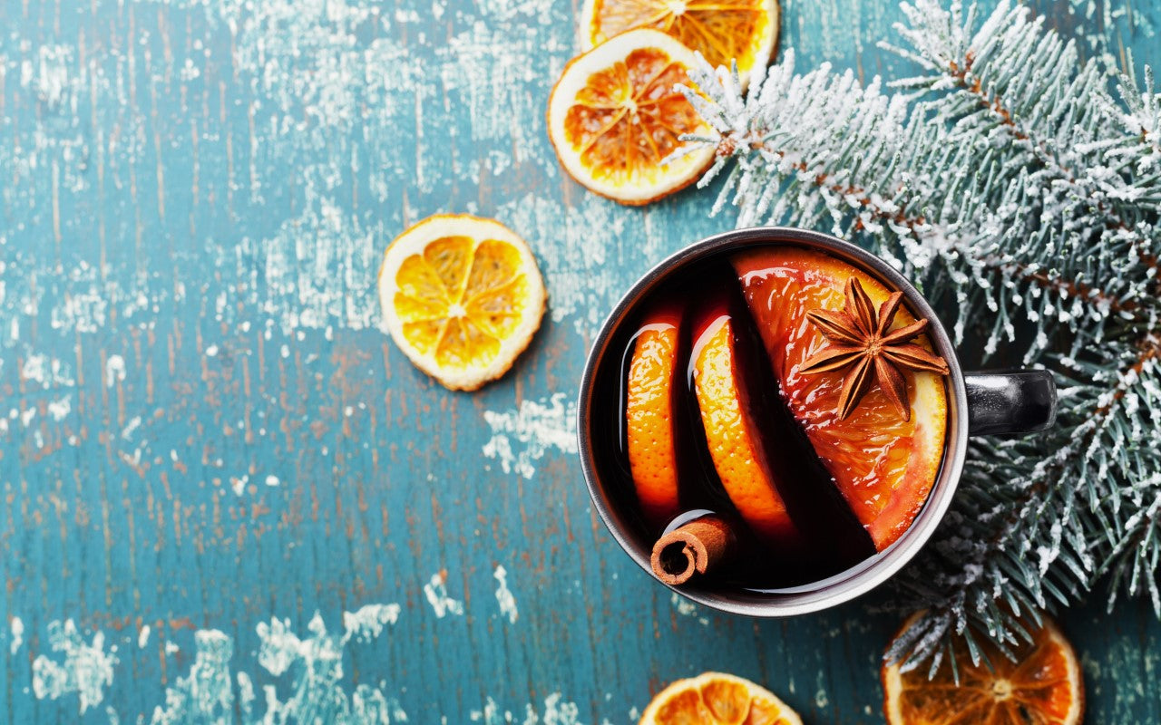 Kop warme alcoholvrije glühwein met sinaasappel, kaneel en steranijs op houten tafel | World of NIX