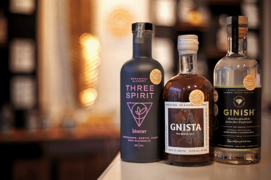 Drie alcoholvrije spirits op rij, Three Spirit, Gnista en GinISH, op toonbank | World of NIX