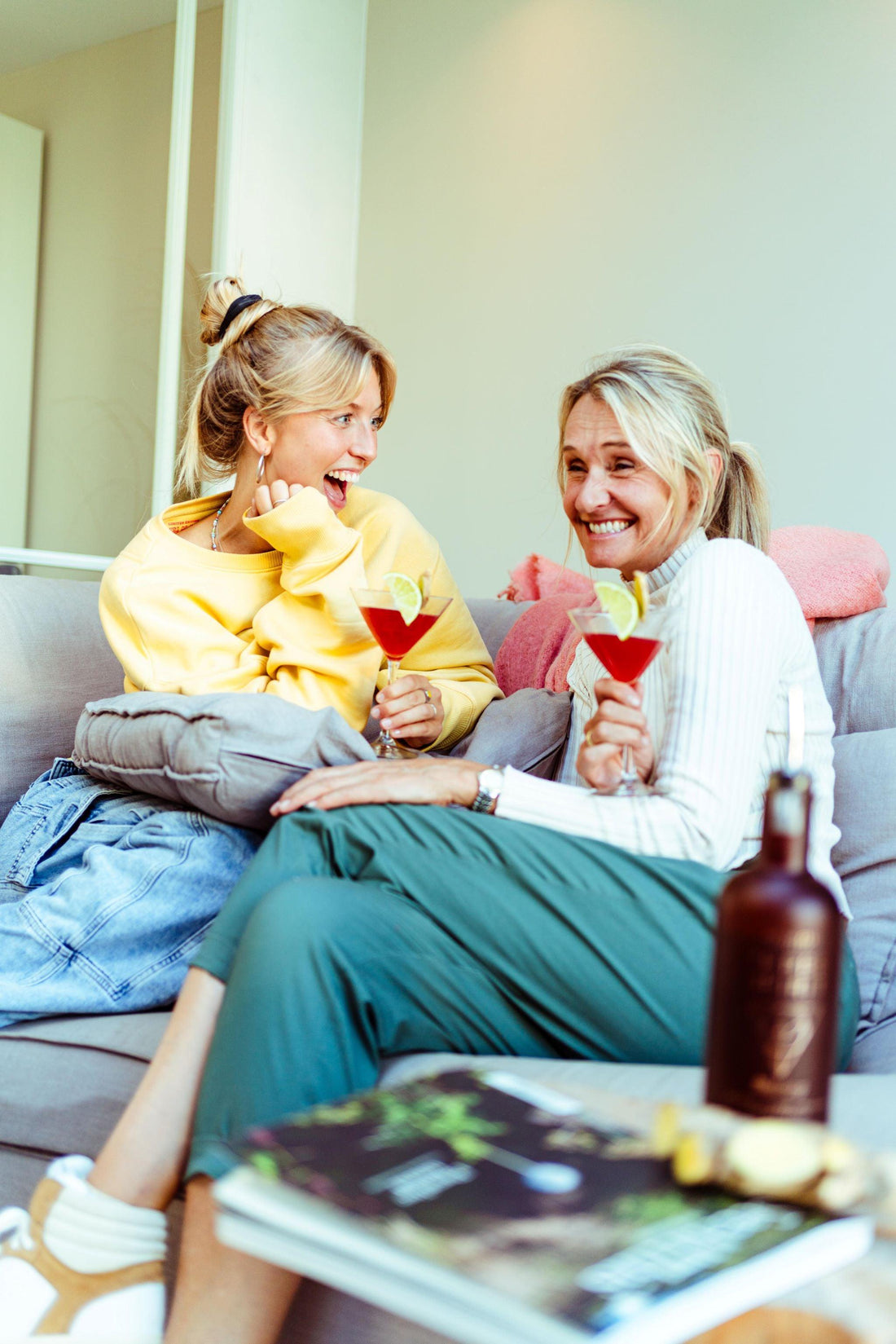 Twee vrouwen lachen samen op de bank met alcoholvrije cocktails, gezellige sfeer | World of NIX