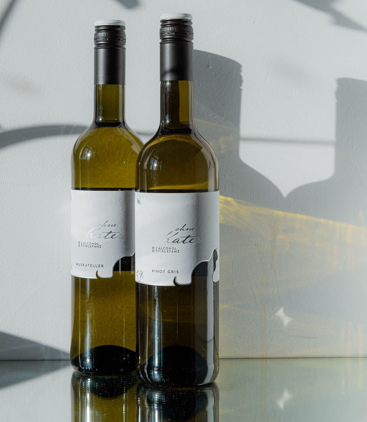 Twee flessen alcoholvrije witte wijn met moderne labels op glazen oppervlak | World of NIX