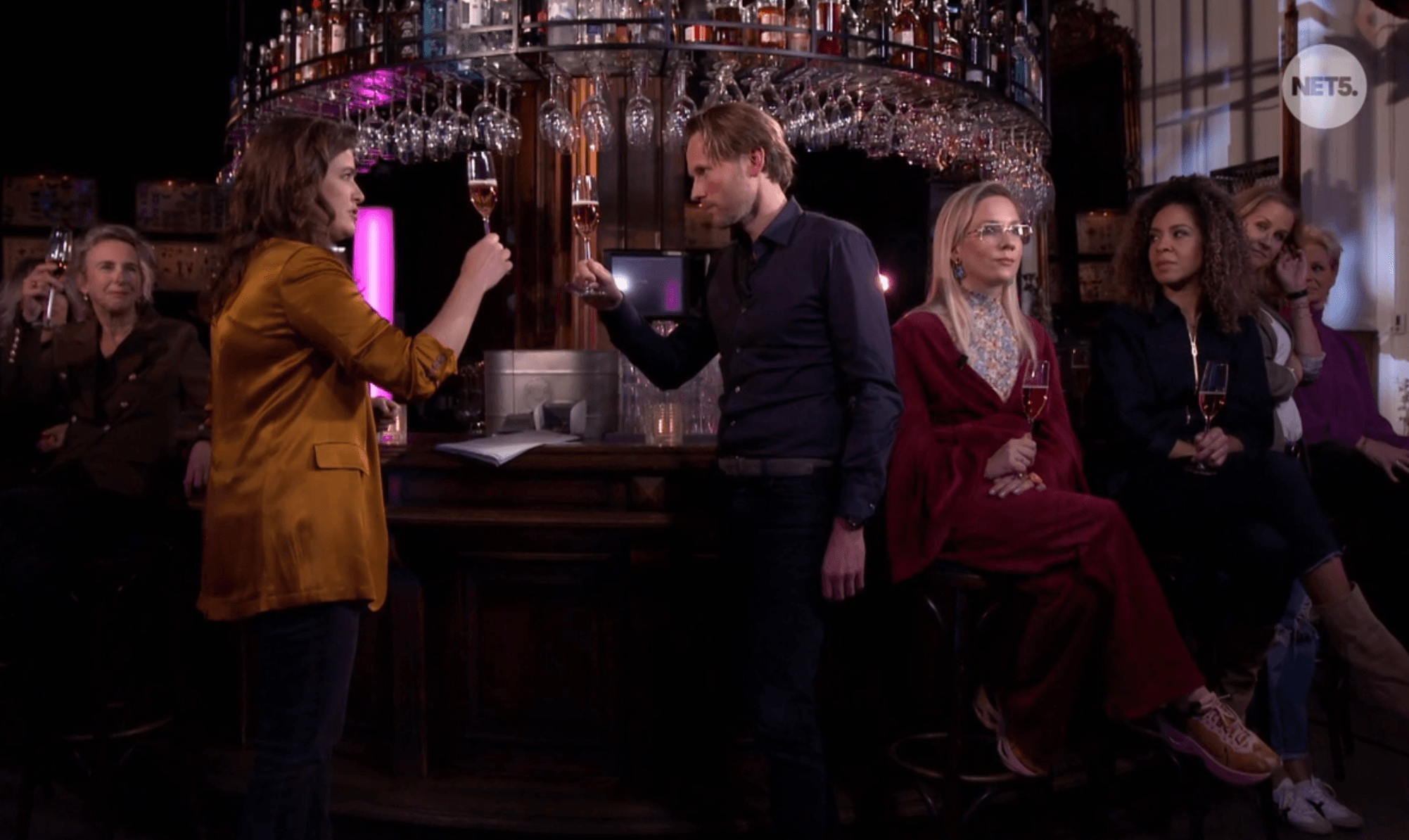 Groep mensen proosten aan bar met alcoholvrije drankjes, gezellige sfeer | World of NIX