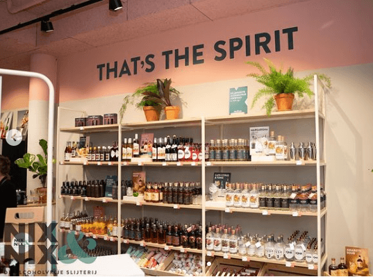 Winkelrek met alcoholvrije spirits, flessen en planten, muurtekst 'That's the spirit' | World of NIX