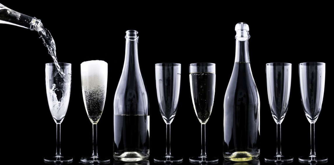 Alcoholvrije bubbels worden in champagneglazen geschonken, zwarte achtergrond | World of NIX