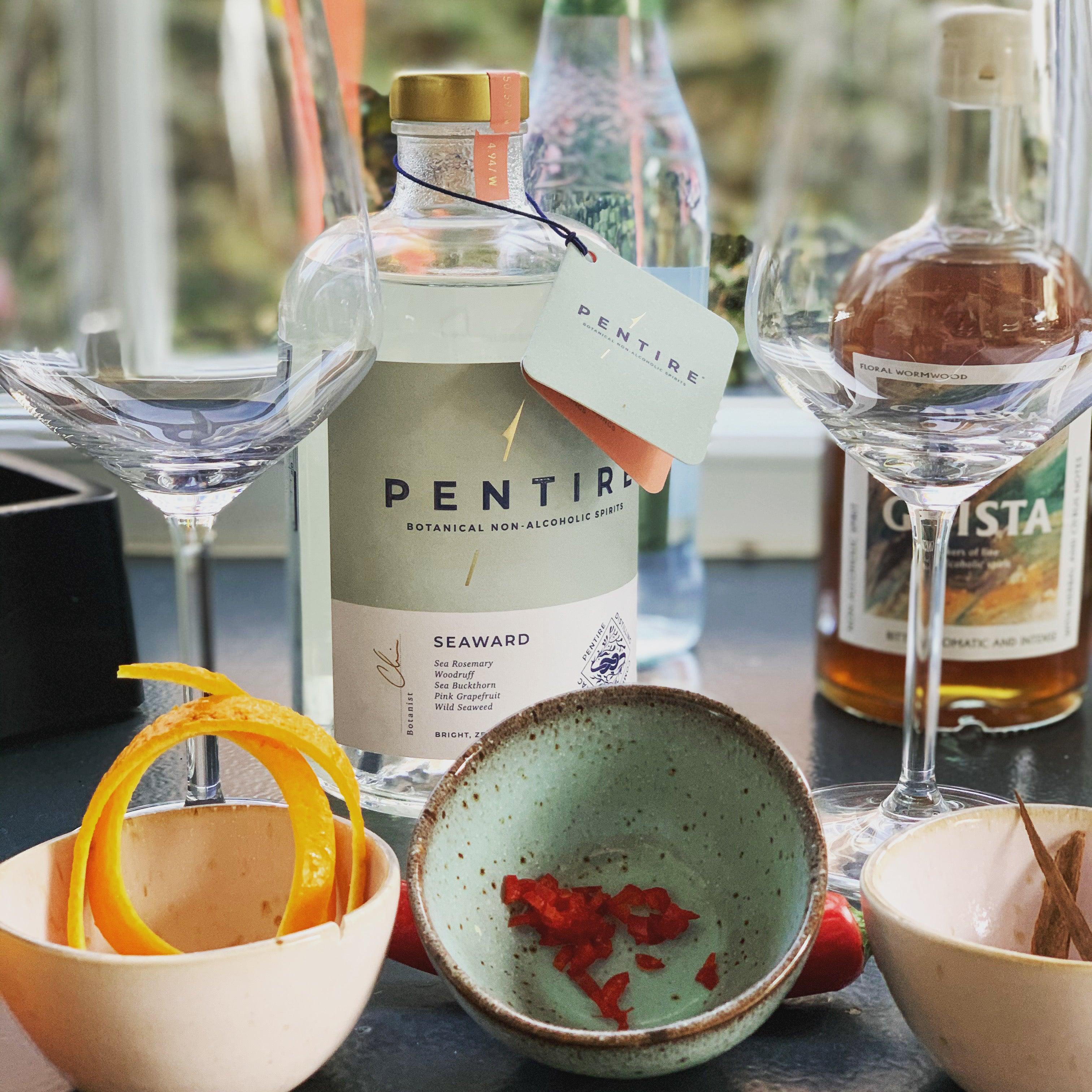 Alcoholvrije spirits Pentire en Gnista met glazen, sinaasappelschil en kruiden op tafel | World of NIX