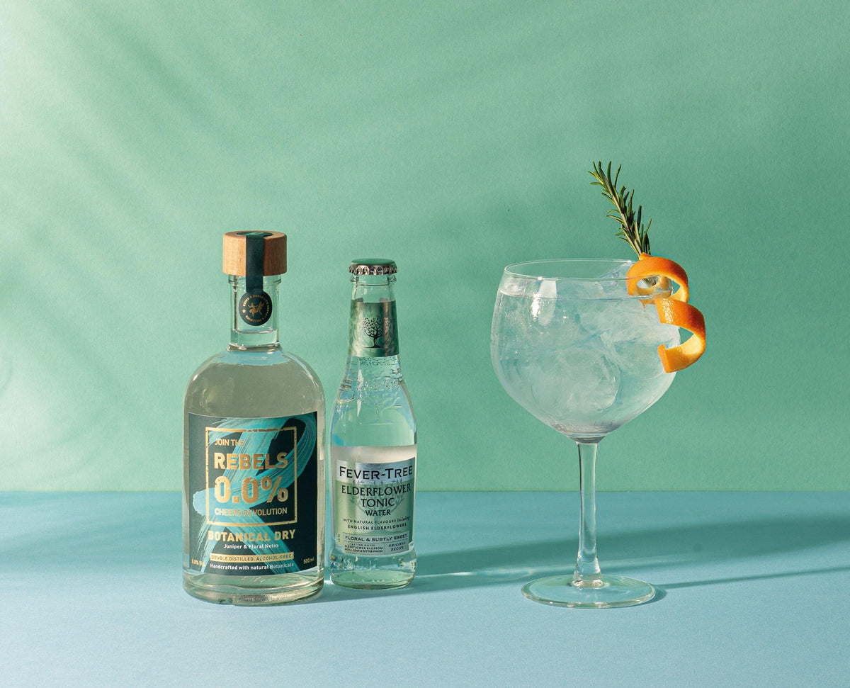 Fles REBELS 0.0% gin, Fever-Tree Elderflower tonic en alcoholvrije gin tonic met sinaasappel en rozemarijn op blauwe ondergrond | World of NIX