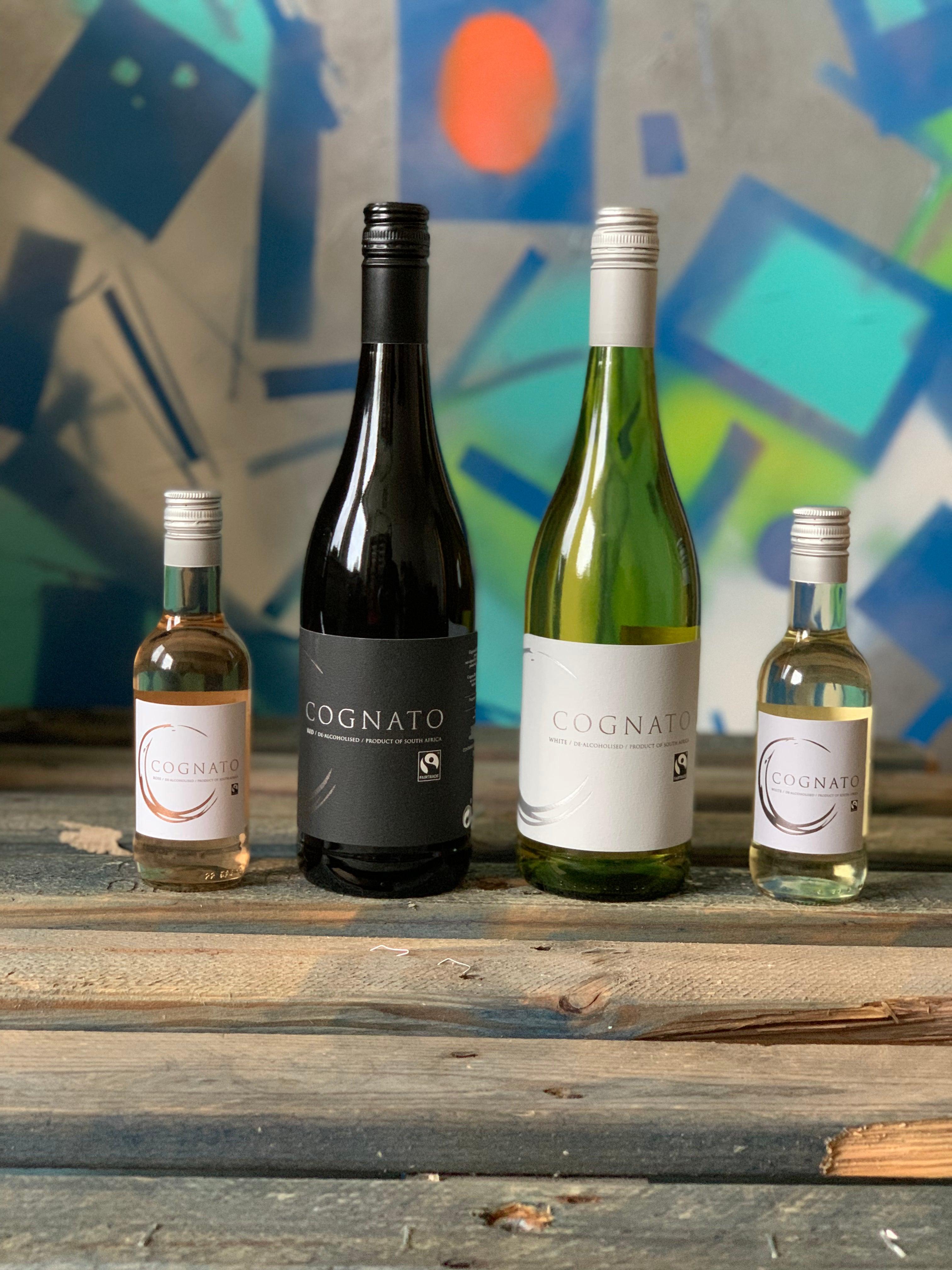 Vier flessen alcoholvrije Cognato wijn op houten tafel met kleurrijke achtergrond | World of NIX