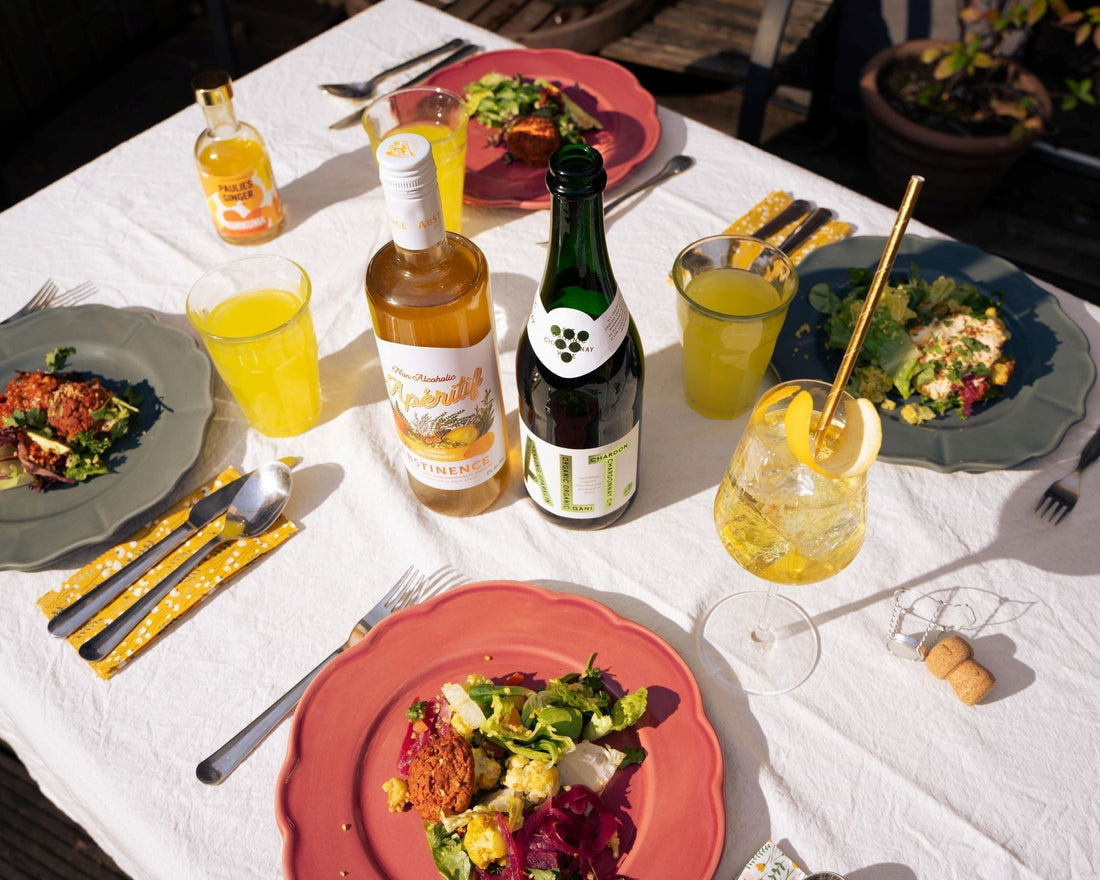 Feestelijke paastafel met alcoholvrije spirits, frisse salades en gele drankjes buiten | World of NIX