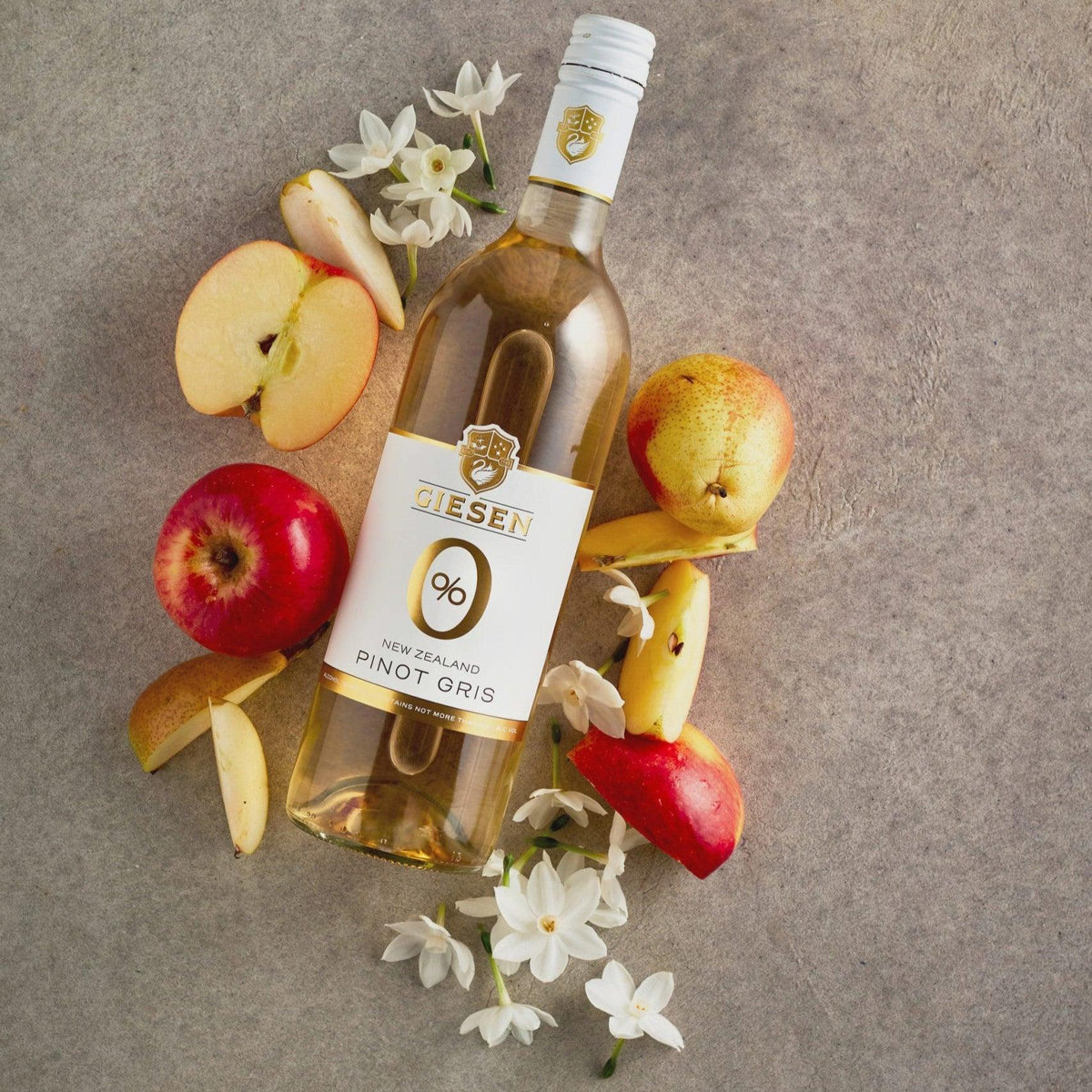 Giesen Pinot Gris alcoholvrije wijnfles met appels, peren en witte bloemen op grijze ondergrond | World of NIX