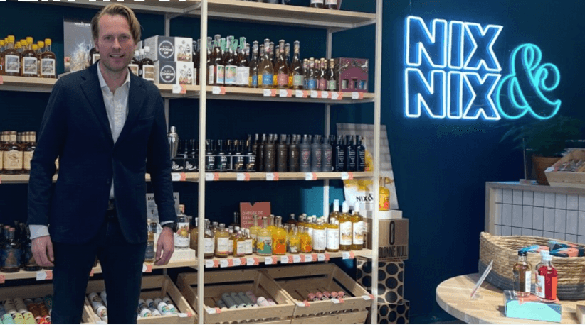 Man in winkel met alcoholvrije spirits, bieren en wijnen, neon NIX & NIX logo | World of NIX