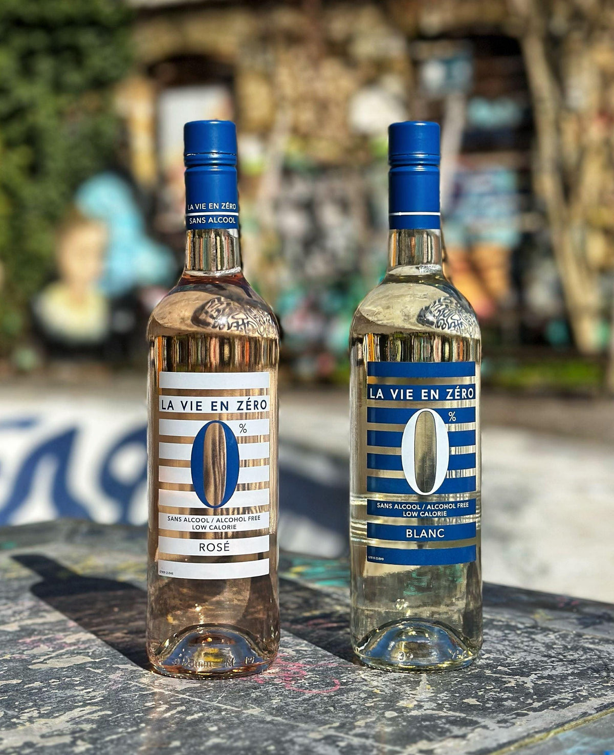 Twee flessen Franse alcoholvrije wijn La Vie en Zéro rosé en blanc buiten op tafel | World of NIX