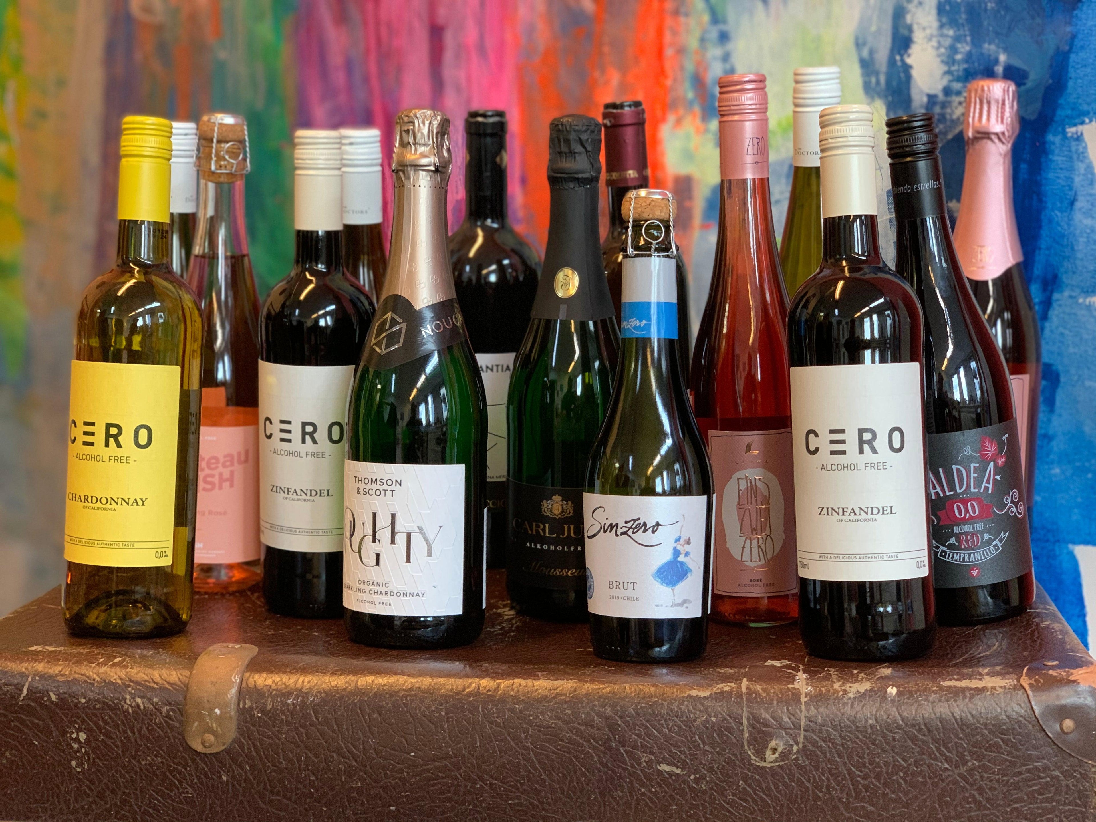 Diverse selectie flessen alcoholvrije wijn en mousserende wijn op een bruine koffer | World of NIX
