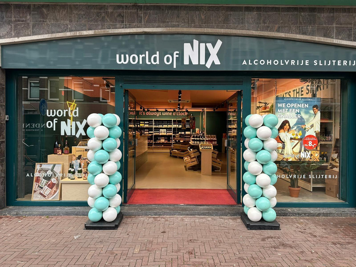Voorkant van World of NIX alcoholvrije slijterij met groene en witte ballonnen bij de ingang | World of NIX