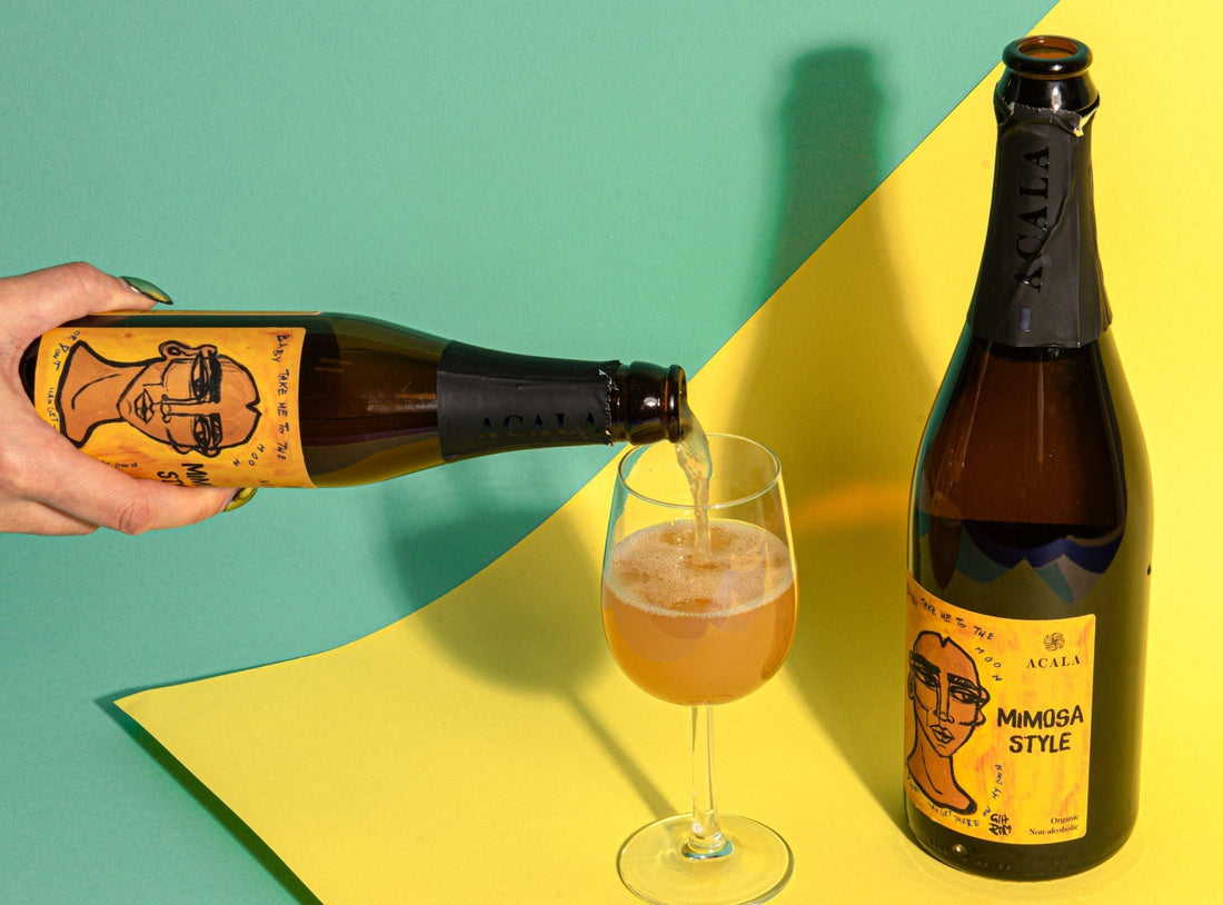 Alcoholvrije Acala Mimosa Style wordt in een wijnglas geschonken op kleurrijke achtergrond | World of NIX