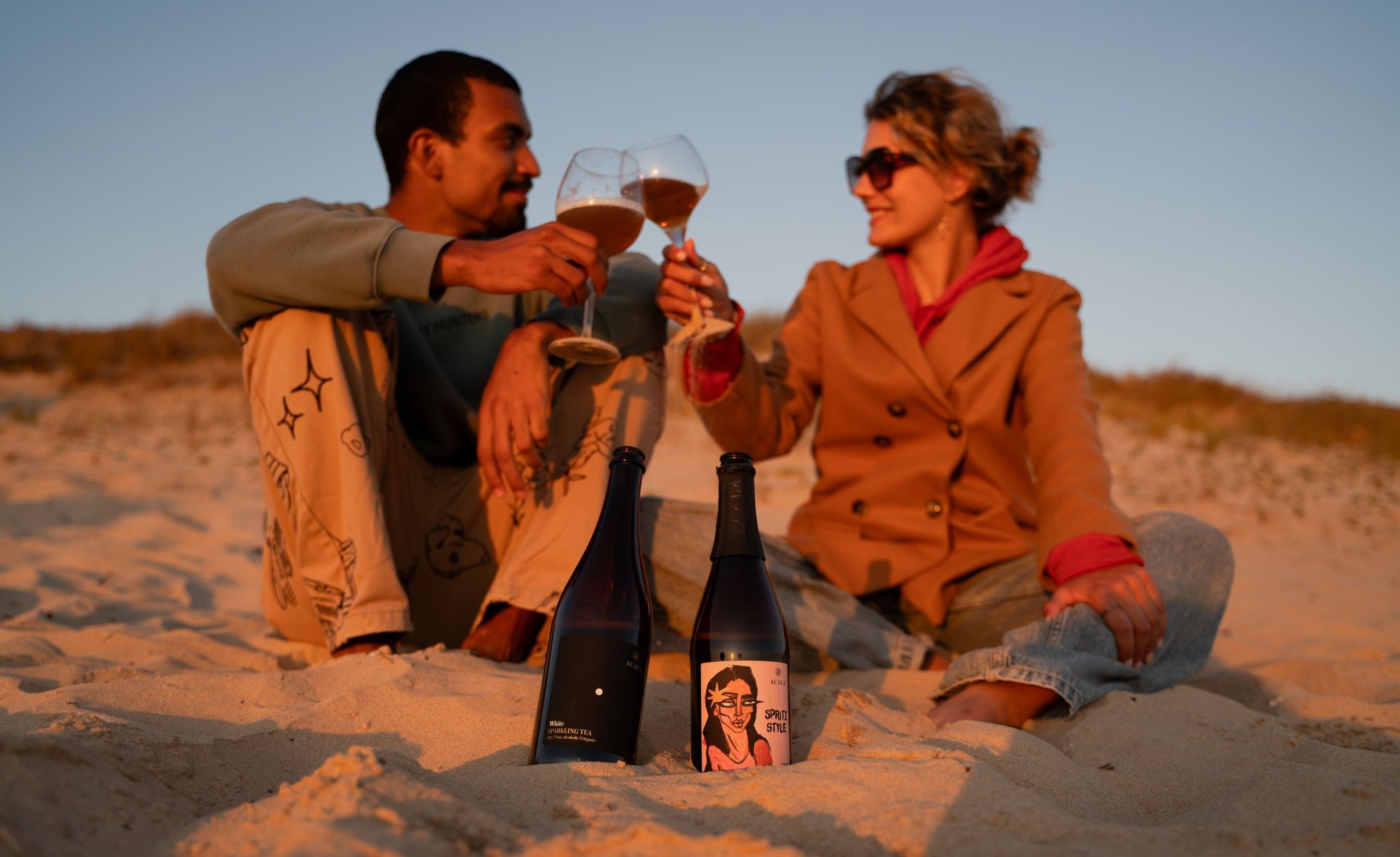 Genieten van sparkling tea van Acala op het strand