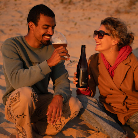 Sparkling tea white wine style van Acala op het strand drinken