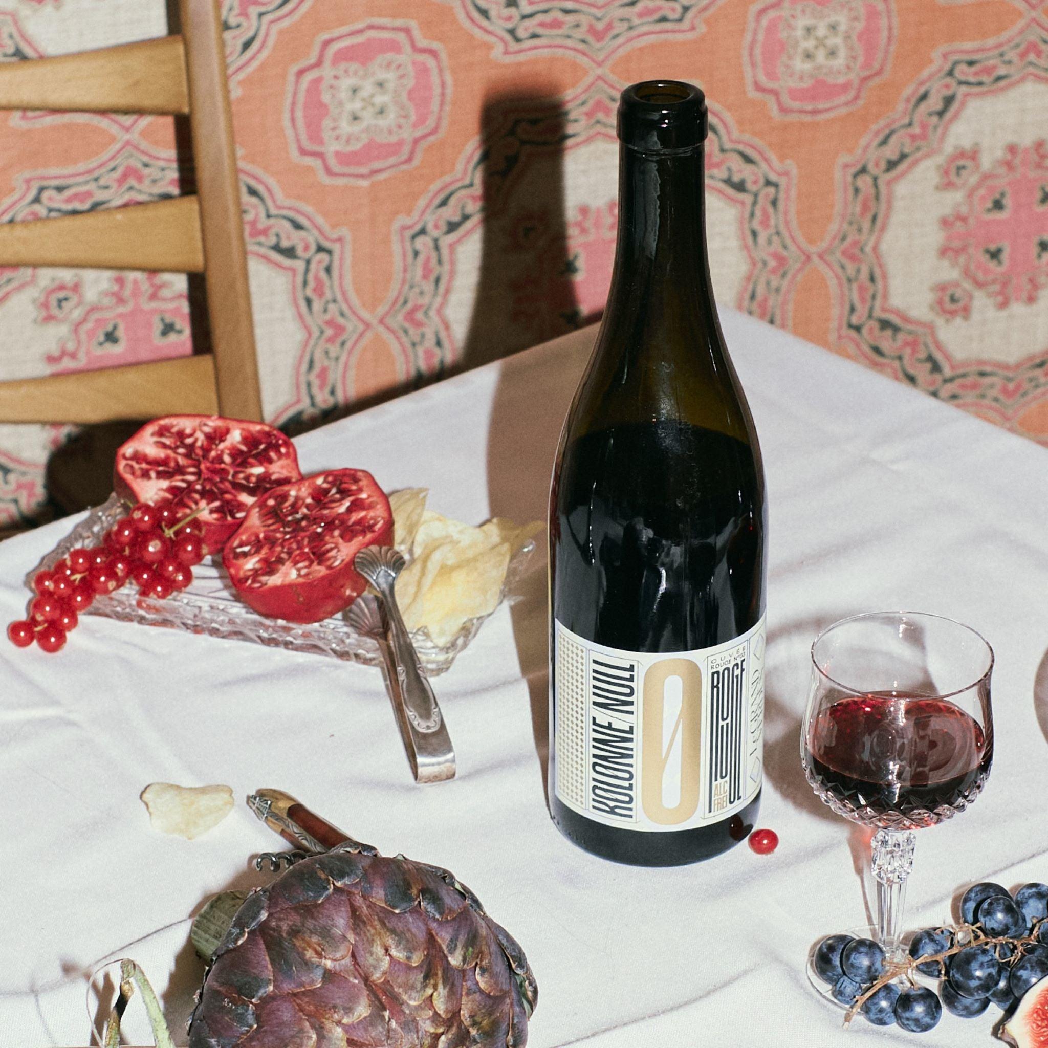 De fles Kolonne Null Cuvee Rouge No 3 gepresenteerd met bijpassende gerechten.