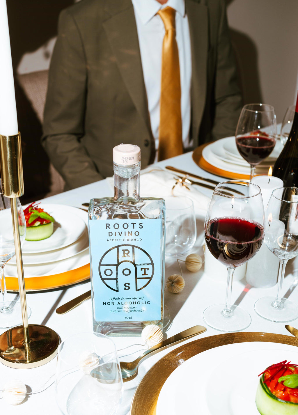 De fles Roots Divino gepresenteerd op een mooi gedekte tafel.