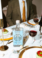 De fles Roots Divino gepresenteerd op een mooi gedekte tafel.